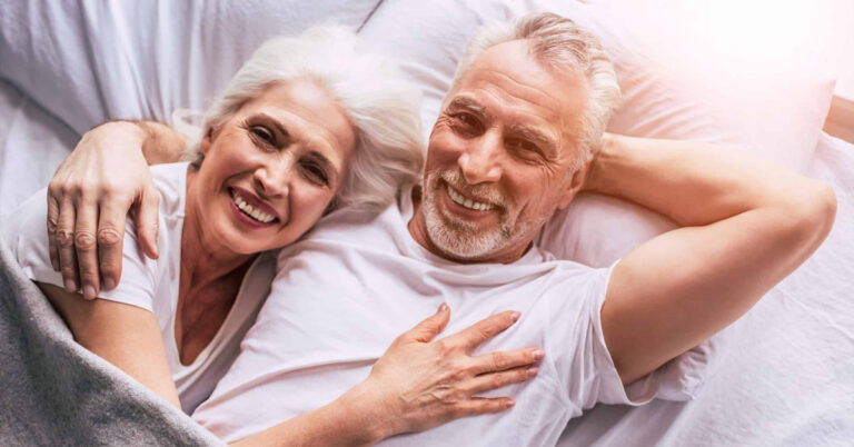 Couple âgé souriant au lit