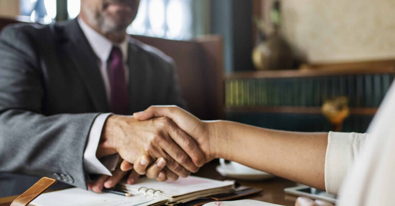 Poignée de main entre deux personnes en costume