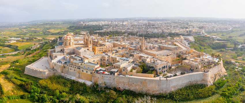 Vue aérienne de Mdina, ancienne capitale fortifiée de Malte, entourée de remparts médiévaux et située dans une campagne verdoyante.